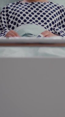 Dikey video: Burun oksijen tüpü takan hasta bir adamın tedavi sırasında yatağında solunum hastalığı olması. Hastanedeki kameraya bakarken doktor bekleyen hasta.