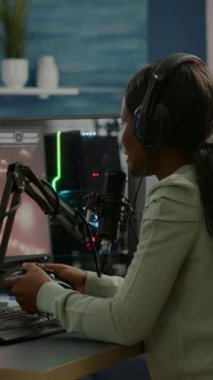 Dikey video: Üzgün Afrikalılar ve spor yayınları çevrimiçi yarışmayı kaybettikten sonra ellerinde joypad tutan kulaklık takarak yüzlerini kapatıyorlar. Pro-oyuncu RGB 'nin güçlü grafikleriyle çevrimiçi video oyunları yayınlıyor