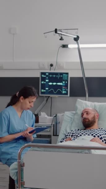 Pionowe Wideo Pielęgniarka Medyczna Omawiająca Leczenie Choroby Szpitalnym Chorym Człowiekiem — Wideo stockowe