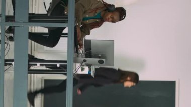 Dikey video: Kıdemli geliştiriciler yazılım ajansı ofisinde dizüstü bilgisayarda kodlama yapıyor, kodları ayrıştırıyor ve dil geliştiriyorlar. Ekip yenilikçi makine öğrenme algoritmaları ve güvenlik duvarı sunucusu kullanıyor.