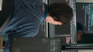 Dikey video: Veritabanı programcısı terminal penceresine çoklu monitör kullanarak kod yazıyor. Sistem yazılım geliştiricisi veritabanı bilgisini yazıyor, büyük veri betiği hesaplanıyor.