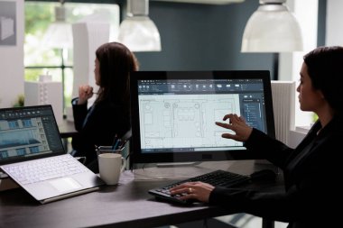 Emlakçı, yazılım, taslak, ev içi kablolar ve bilgisayar monitörlerinde oda planlaması yapıyor. Mimarlık ofisinde Asyalı çalışan, proje planları hazırlıyor.