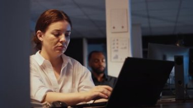 Ofis işindeki akıllı telefondan konuşan, geceleri rapor hazırlamak için dizüstü bilgisayarda çalışan yeni yetme bir çalışan. Yönetici paylaşım verilerini kullanarak ve kurumsal sunum planlayarak. El kamerasıyla..