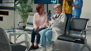 Eski doktor ve Asyalı hasta röntgen sonuçlarına bakıp sağlık merkezindeki radyografi ile hastalık teşhisini açıklıyor. Sıhhiye, reçeteli tedavi ile destek, sağlık hizmeti.