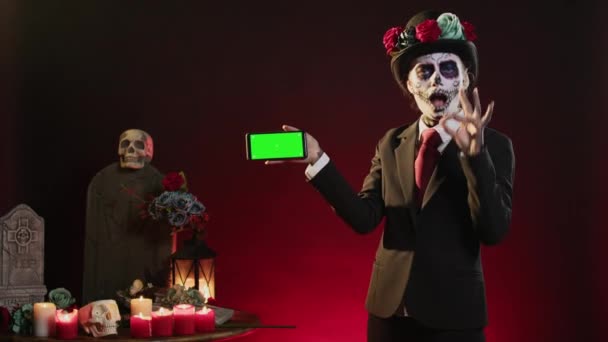 Santa Muerte Tenendo Schermo Verde Orizzontale Sul Telefono Cellulare Guardando — Video Stock