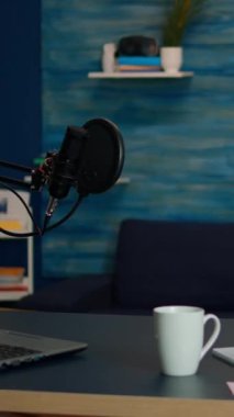 Dikey video: Rahat bir stüdyoda çalışan genç vlogger 'ın portresi, kameraya gülümsüyor ve yeni bir podcast şovu başlatmaya hazır. Çevrimiçi prodüksiyon internet yayınları sunucu web içeriği kaydını gösteriyor