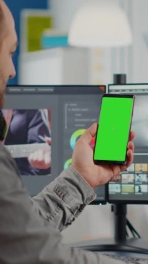 Video editörü elinde yeşil ekranlı akıllı telefonu tutarak konuşuyor, kroma tuşu, başlangıç ofisinde otururken filmi rötuşlamaya ara vererek izole edilmiş görüntüyü taklit ediyor. Ekip arka planda çalışıyor