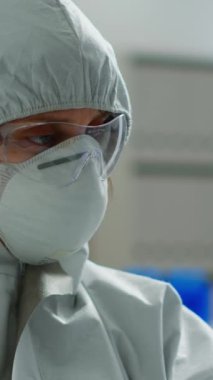 Dikey video: Modern donanımlı laboratuvarda tüp içinde sıvı analizi yapan bir bilim adamı. Aşı evrimini inceleyen biyokimyacı, tedavi geliştirmek için yüksek teknoloji kullanıyor.