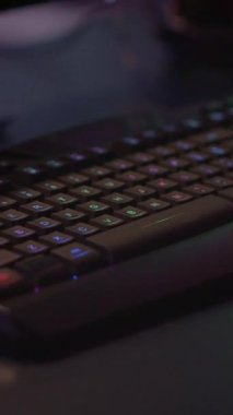 Dikey video: Profesyonel klavyeyi kapatın ve RGB ışıklandırması çevrimiçi turnuva için hazır olsun. Esport video oyununun oyun stüdyosu