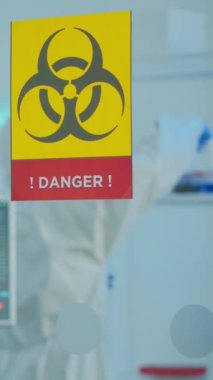 Dikey video: Korunma giysisi giyen kimyacı doktorlar tıbbi araştırma laboratuvarının tehlikeli bölgelerinde çalışıyorlar. Aşı evrimini inceleyen bilim adamları tedavi için yüksek teknoloji kullanıyorlar.