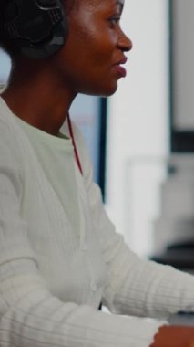 Afrikalı video editörü kulaklıkla müzik dinliyor, kurgu görüntüleri ve sesleri kaydediyor yaratıcı ajansta oturuyor. Yapım sonrası yazılımı olan dijital multimedya şirketi işleme filminde kameraman