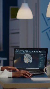 Afrika 'lı kadın mühendis, modern kurum programında çalışıyor. Alet edevatı yeni açılan iş ofisinde masada oturuyor. Endüstri çalışanı prototip fikrini bilgisayarda çalışıyor. Adi yazılımlar görüntüleniyor.