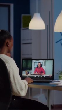 Afrikalı serbest çalışan ve internetten kadın partnerle tartışan bilgisayar başında gece yarısı sanal toplantı sırasında konuşan, kulaklık kullanan, fazla mesai yapan biri.