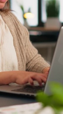 Lapotop 'un önünde oturan, gülümseyen, yeni başlayan finans şirketinde çalışan, gerçek, mutlu, profesyonel bir çalışanın e-postalarını kapatın. Çeşitli takımlar modern ofisteki istatistik verilerini analiz eder