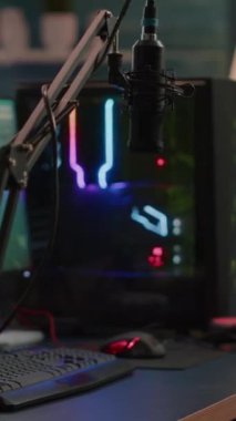 Dikey video: Oyun RGB profesyonel güçlü bilgisayar ekranında sona erdi ve canlı sohbet sanal turnuva için hazırlanıyor. Boş oyun stüdyosundaki profesyonel mikrofon...