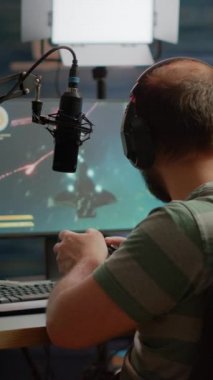 Dikey video: Heyecanlı çift oyuncu RGB güçlü bilgisayarında el kaldırarak birinci şahıs nişancı online video oyunu kazanıyor. Profesyonel siberler turnuva esport şampiyonasında gösteri yapıyorlar.