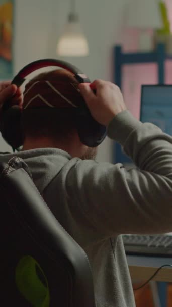 垂直ビデオ 強力なパーソナルコンピュータ上で遊んで幸せな男のゲーマーの最初の人のシューティングゲームのビデオゲームを獲得のバックショット テクノロジーを使用したゲームトーナメント中のオンラインストリーミングサイバーパフォーマンス — ストック動画