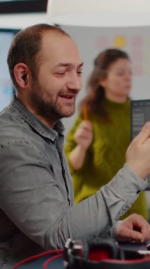 Video editörü elinde akıllı telefon kurgu filmiyle yaratıcı ajansla konuşuyor. Dijital multimedya şirketinde post prodüksiyon yazılımı ile video yönetmeni montajı