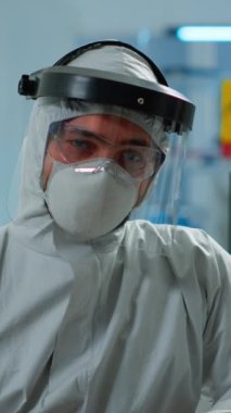 Dikey video: Bilimsel donanımlı laboratuvarda çalışan yorgun kimyager adam doktorunu kapatın. Çeşitli bakteri, doku ve kan örnekleri, ilaç araştırmaları üzerinde çalışan bilim adamları