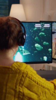 Dikey video: Bilgisayar oyununda oynayan profesyonel esport oyuncusu, mutlu ve neşeyle zaferi ve başarıyı kutluyor. Çevrimiçi siber oyun turnuvası teknolojiyi kullanarak canlı yayın etkinliği