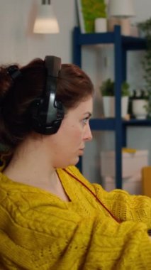 Dikey video: Profesyonel esport kadın oyuncu bir şampiyonluk maçında video oyununda yarışırken kameraya gülümsüyor. Çevrimiçi canlı siber performans sırasında güçlü kişisel bilgisayarda