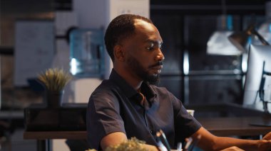 Şirket ofisinde işe başlama raporunu planlamak için dizüstü bilgisayar kullanan kendine güvenen bir çalışan, profesyonel bir sunum yaratmak için gece geç saatlere kadar çalışıyor. E-ticaret verileri ve iş paylaşımları içeren yönetici e- postaları yazılıyor.