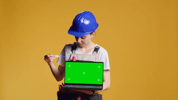 Sarı Arkaplan Üzerinde Yeşil Ekranlı Dizüstü Bilgisayarı Tutan Becerikli Kadının — Stok fotoğraf