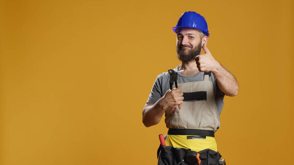 Portrait of craftsman showing thumbs up gesture in studio, expressing approval and agreement. Feeling confident and doing positive like sign, being cheerful about satisfaction and success.