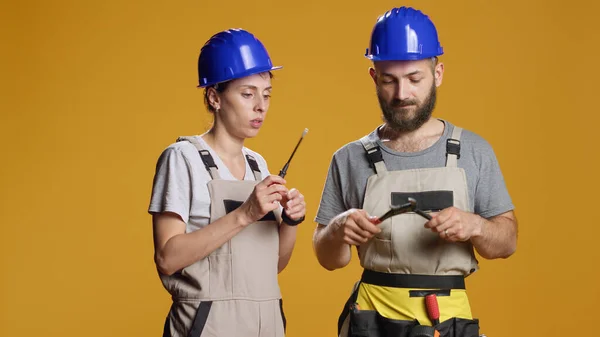 男男女女建筑工人使用螺丝刀和扳手从事建筑和工业翻新工作 承包商小组在工作室使用修理工具 旋转螺丝和扳手 — 图库照片
