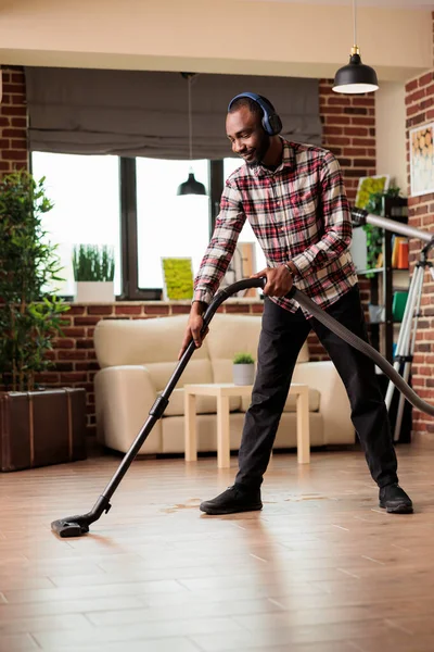 Lachende Afro Amerikaanse Man Met Draadloze Headset Reinigen Vloer Thuis — Stockfoto