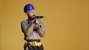 Tamircinin portresi yenileme ve yenileme için elektrikli matkap kullanıyor. Makinist, endüstriyel onarım için çivi tabancasıyla çalışıyor..