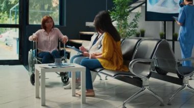 Tekerlekli sandalyedeki hastaya danışmanlık yapan yaşlı bir uzman, klinikte kronik sakatlıktan muzdarip. Fiziksel engelli bir doktor, sağlık merkezi..
