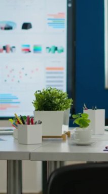 Konferans masası beyin fırtınası için hazır olan rahat ışık şirketi odasının içi modern şık sandalyeler ve masa başı monitörleri çalışanlar için hazır. Yaratıcı çalışma alanının boş geniş ofisi.
