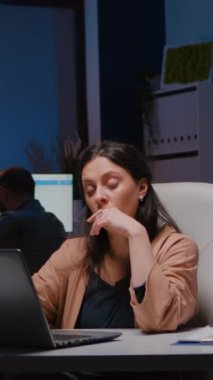 Ekonomik istatistikleri analiz eden dizüstü bilgisayarda finansal strateji yazan yorgun işkolik yönetici kadın. Girişim şirketinde çalışan iş kadını gece geç saatlerde raporları kontrol ediyor.