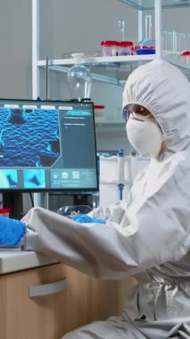 Dikey video: Kimyager donanımlı laboratuvarda virüs testine bakıyor. Çeşitli bakteri, doku ve kan örnekleriyle çalışan bilim adamları, antibiyotikler için ilaç araştırmaları kavramı