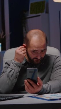 Girişimci şirket ekibiyle telefon yönetimi toplantısı hakkında sohbet ediyor. Ekip toplantısı sırasında ekonomik stratejiyi tartışıyorlar. Girişim ofisinde gece geç saatlere kadar çalışan bir işadamı