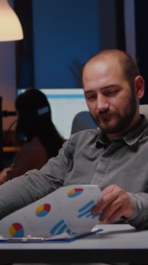 Masada oturup finansal istatistikleri analiz eden gülümseyen iş adamının portresi. Şirketin son teslim tarihinden önce şirket ofisinde çalışan bir yönetici.