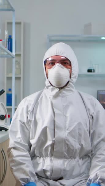 垂直ビデオ 化学実験室で仮想現実を扱うパイプスーツのラボ技術者 高度な技術と技術を駆使してワクチンの進化を調べる生物学者チーム — ストック動画