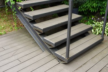 Sokakta metal parmaklıklı ahşaptan basamaklar, hareket yönü.