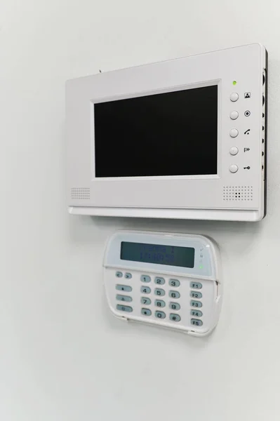 wall-mounted monitor of the video surveillance system in the interior of the office space, remote electronic key for the alarm system and the password entry system