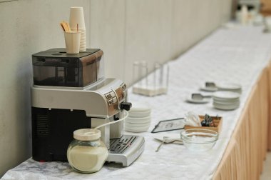 Seminer ziyaretçileri ve kahve makinesi için sıcak su dolu çaydanlıklar.