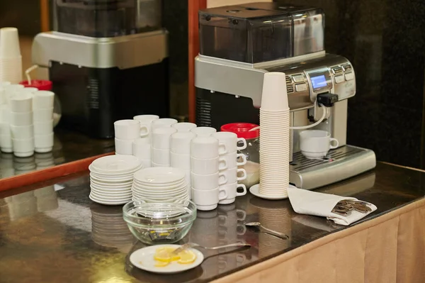 Etkinliğin resepsiyonunda kahve seti, kahve makinesi ve sıcak su ısıtıcıları seminer ziyaretçileri için masada.