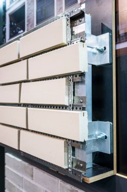 Duvarlara tuğla döşeyen, yakından çekilen bir sistem örneği