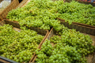 fresh grapes in a wicker box in the supermarket on the counter for the free choice of buyers