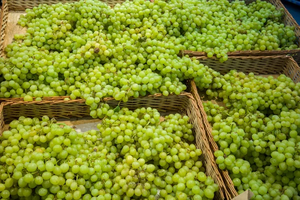 fresh grapes in a wicker box in the supermarket on the counter for the free choice of buyers