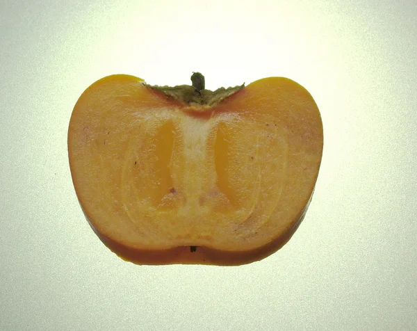Pół persimmon, podświetlane od tyłu — Zdjęcie stockowe