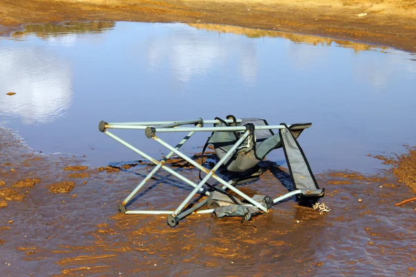 Trasiga solstol på sanden — Stockfoto