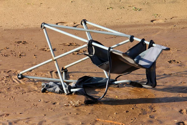 Сломанное пляжное кресло на песке — стоковое фото
