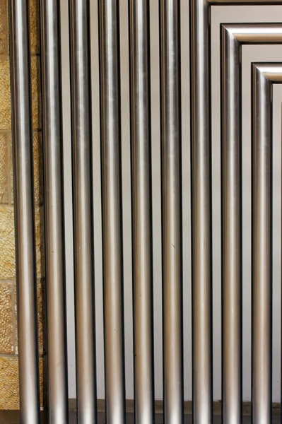 A stainless steel tubes against the wall