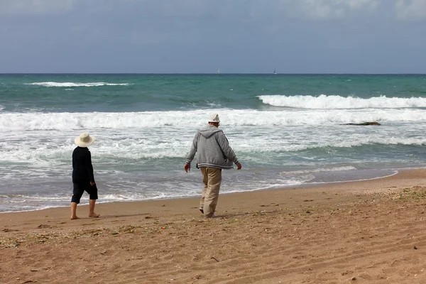 Casal sênior caminhando separadamente na praia — Fotografia de Stock
